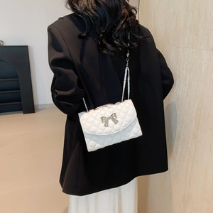 Minimalist white quilted shoulder bag with metal bow buckle and elegant chain strap