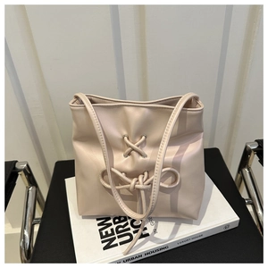 Detail of soft pink leather bucket bag with ribbon bow knot and metallic eyelets