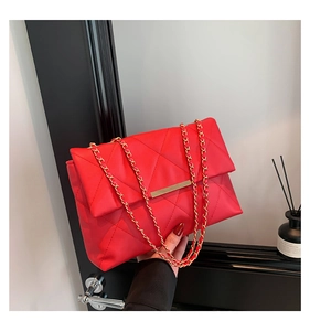 Dettaglio della borsa a tracolla trapuntata rossa con catena dorata e chiusura in metallo