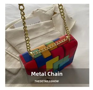 Detail of colorful geometric patchwork shoulder bag with gold chain and metal connection