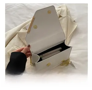 Detail view of white flap crossbody bag showing interior capacity and gold metal trim