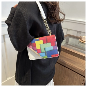 Detail of colorful Tetris pattern on a trendy crossbody bag with gold chain strap