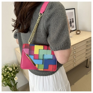 Detail of crossbody bag featuring colorful geometric blocks and golden metal chain strap