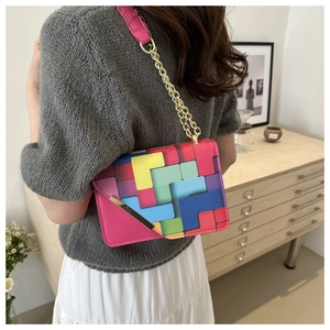 Detail of colorful geometric print flap bag with gold chain strap on female model