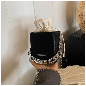 Detail of black crossbody bag with silver chain and Rich Rabbit embossed logo
