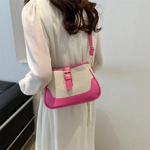 Pink and cream canvas crossbody bag with gold buckle shown on a model's shoulder