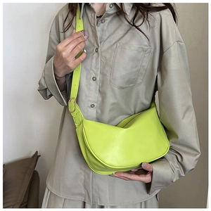 Detail of lime green crescent shoulder bag with soft leather texture and golden buckle