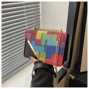 Close-up of colorful patchwork crossbody bag with gold chain strap and leather texture