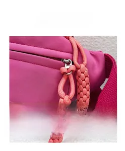 Vue détaillée de la fermeture éclair en métal et du cordon tressé magenta du sac en toile