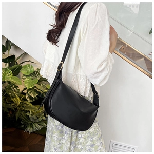 Detail view of black PU leather crescent crossbody bag with adjustable strap and gold buckle