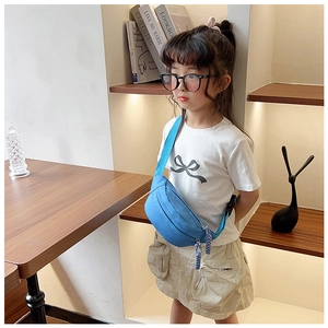 Enfant portant un sac banane en toile bleu vif avec sangle réglable et détail zippé