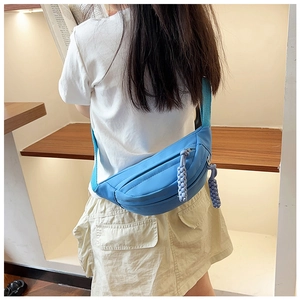 Détail du sac banane enfant bleu ciel en toile avec des tirettes de fermeture éclair tressées
