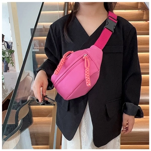Détail du sac de poitrine rose pour enfant avec zips orange et sangle réglable