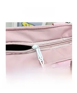 Gros plan du sac en toile rose montrant la fermeture éclair blanche et la texture