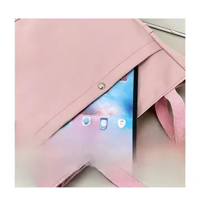 Gros plan d'un sac en toile rose avec poche avant spacieuse et fermeture à bouton pression
