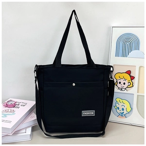 Détail du sac en toile noir avec logo FASHION en métal et bandoulière réglable