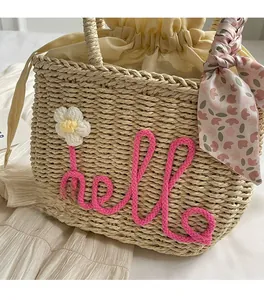 Detail of straw woven handbag featuring hello rope embroidery and a floral scarf