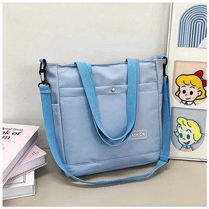 Détail du sac fourre-tout bleu clair avec poche à pression et bandoulière réglable