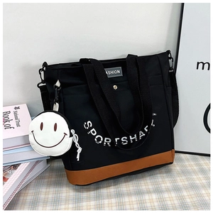 Dettaglio della borsa tote in tela con base a contrasto e mini portamonete a forma di smile