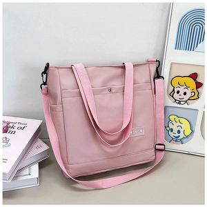 Vue détaillée du sac cabas rose en nylon avec étiquette fashion et bandoulière réglable