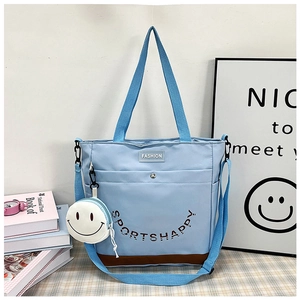 Dettaglio della borsa tote azzurra con piccolo portamonete a forma di faccina