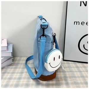 Dettaglio della borsa tote in tela azzurra con fondo marrone e portamonete smiley