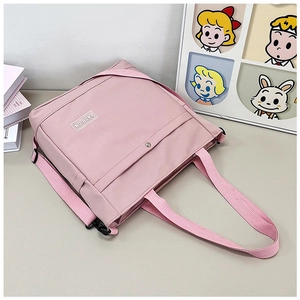Détail du sac fourre-tout rose en toile montrant le bouton pression et l'étiquette FASHION