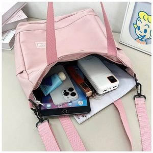 Détail de l'intérieur d'un sac en toile rose montrant un grand espace pour tablette