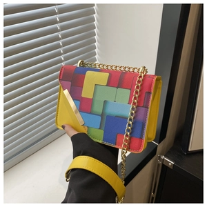 Detailed view of vibrant Tetris-style geometric print on yellow leather crossbody bag