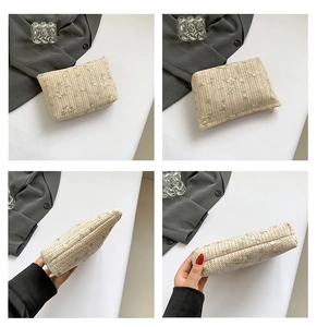 Detailed views of beige straw clutch with floral embroidery and secure zip closure