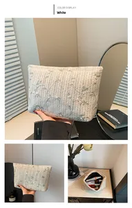 Detail view of woven makeup bag with floral embroidery and top zipper closure