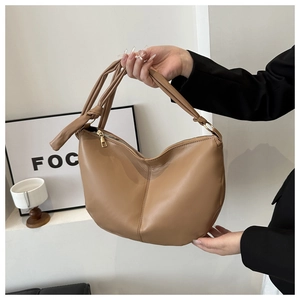 Detail view of the khaki half-moon tote bag featuring a stylish knotted shoulder strap