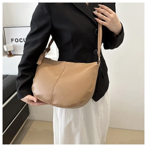 Detail of a large khaki leather hobo bag with knotted wide shoulder strap and minimal design