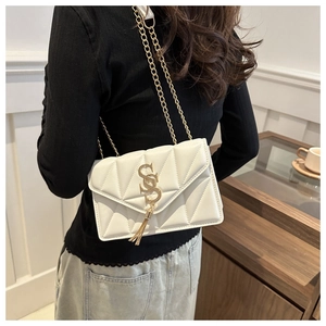 Close-up of a white quilted crossbody bag with gold SS logo and chain strap on a model