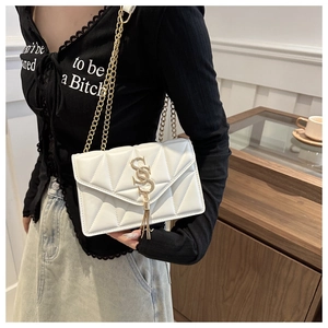 Close-up of white quilted leather crossbody bag with gold SS logo and tassel detail