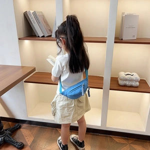 Sac banane bleu pour enfants en nylon avec sangle réglable porté par une petite fille