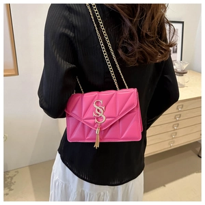 Detail of magenta chain shoulder bag with diamond stitching and golden tassel charm
