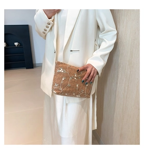 Close-up of woven crossbody bag featuring delicate white flower embroidery details