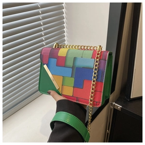 Close-up of geometric pattern flap and gold chain strap on green square crossbody bag