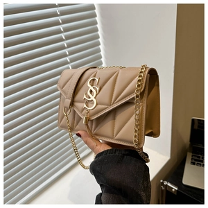 Detail of beige quilted shoulder bag with gold chain strap and decorative tassel