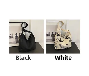 Detail of embroidered floral butterfly patterns on black and cream canvas tote bags