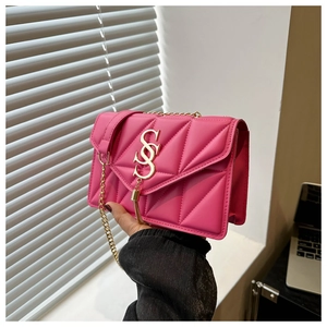 Detail of rose pink quilted crossbody bag with golden chain and metallic SS logo