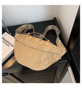 Dettaglio ravvicinato della borsa a tracolla beige in tela plissettata con cinturino in nylon