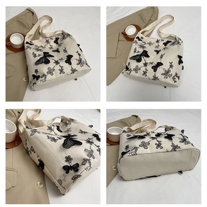 Detail of canvas tote bag featuring 3D black lace butterfly and floral embroidery