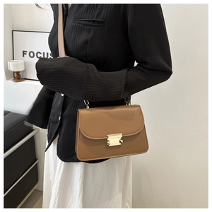 Détail du sac carré en cuir caramel avec boucle en métal doré et bandoulière élégante