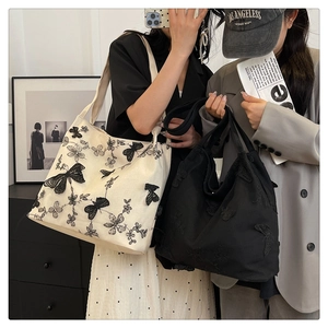 Detailed close-up of intricate butterfly embroidery on the canvas tote shoulder bag