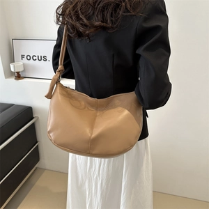 Minimalist light brown leather tote bag with knotted strap and crescent shape for women
