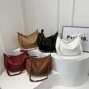 Collection of minimalist leather hobo bags in five colors on geometric display stands