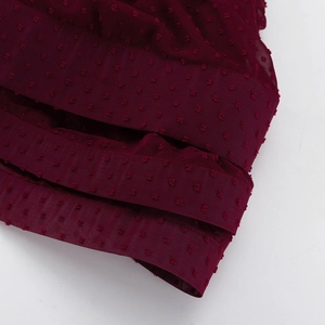 Detaillierte Nahaufnahme von dunkelrotem Chiffon mit Swiss-Dot-Struktur und Netznaht