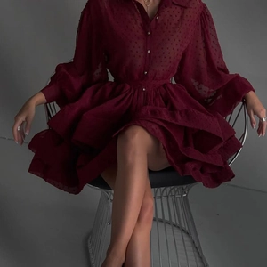 Detail des burgunderroten Chiffonkleids mit Polka-Dot-Struktur und gestuften Volants